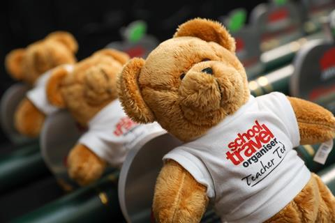 Teacher Ted leaning against the School Travel Awards 2025 trophies